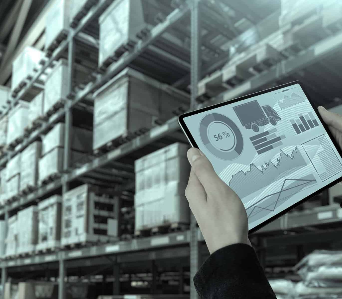 a person holding a tablet in front of a warehouse